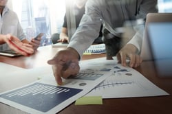 Double exposure of businessman hand working with new modern computer and business intelligence reports as concept